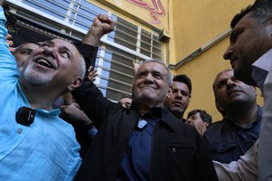 Reformist candidate for the Iran's presidential election Masoud Pezeshkian clenches his fist after casting his vote as he is accompanied by former Foreign Minister Mohammad Javad Zarif, left, at a polling station in Shahr-e-Qods near Tehran, Iran, Friday, July 5, 2024. Iranians are voting in a runoff election to replace the late President Ebrahim Raisi, who was killed in a May helicopter crash in the country’s northwest along with the foreign minister and several other officials.